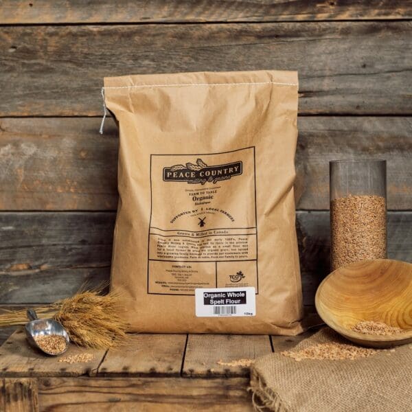 A bag of grain sitting next to a wooden bowl.